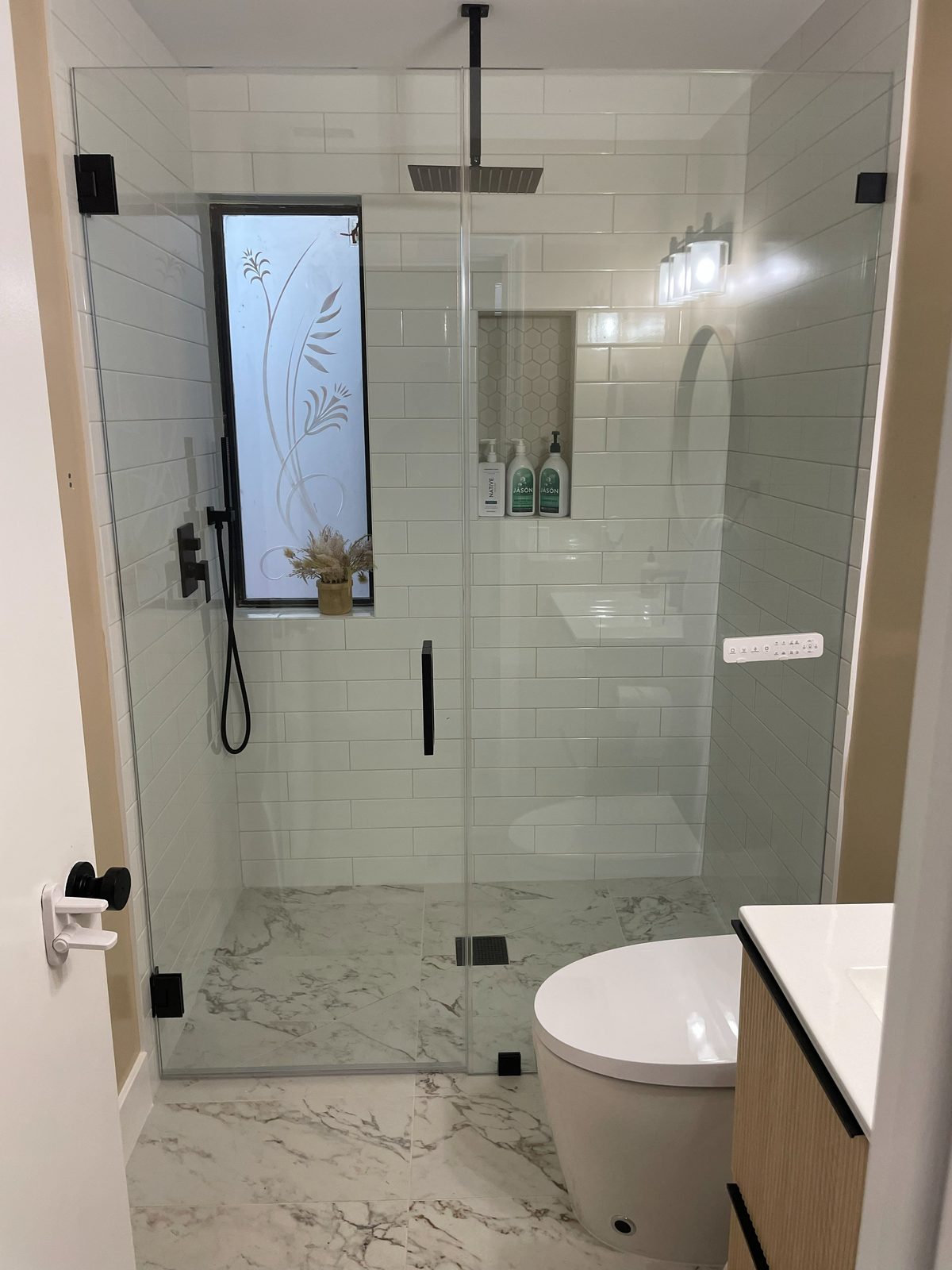Full bathroom remodel with marble floor and glass shower