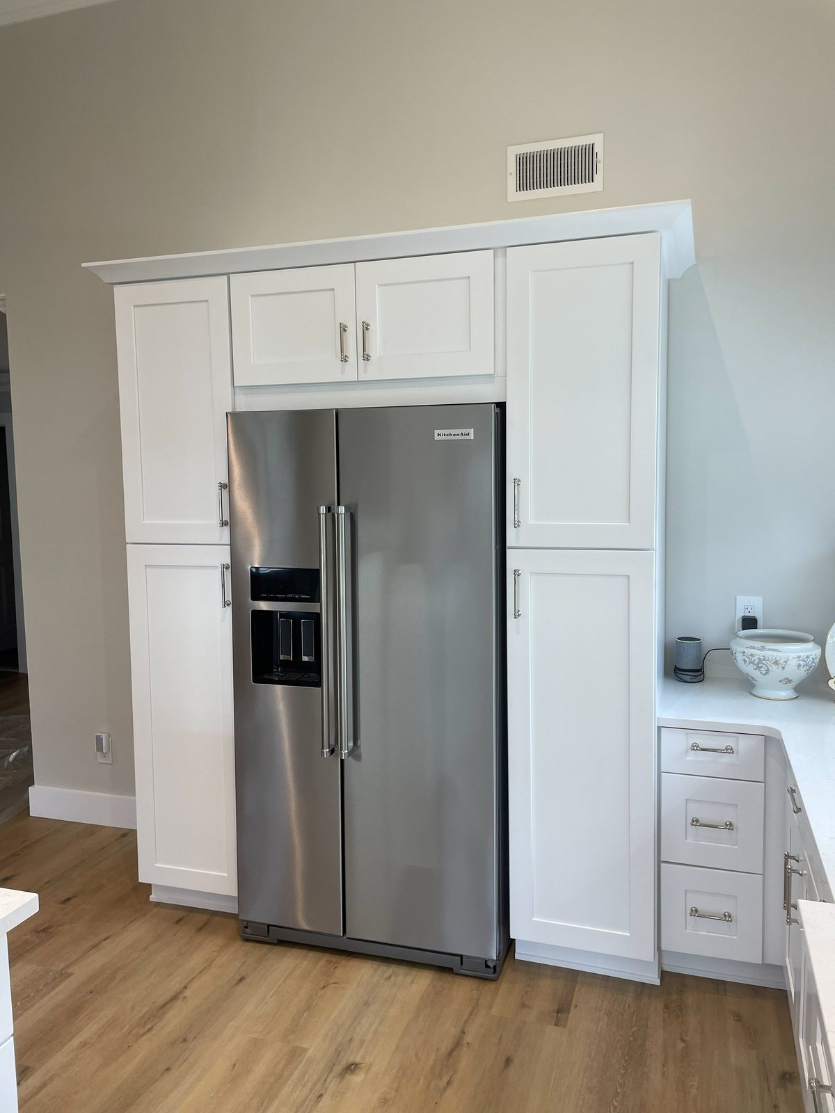 White shaker pantry wall built around stainless refrigerator